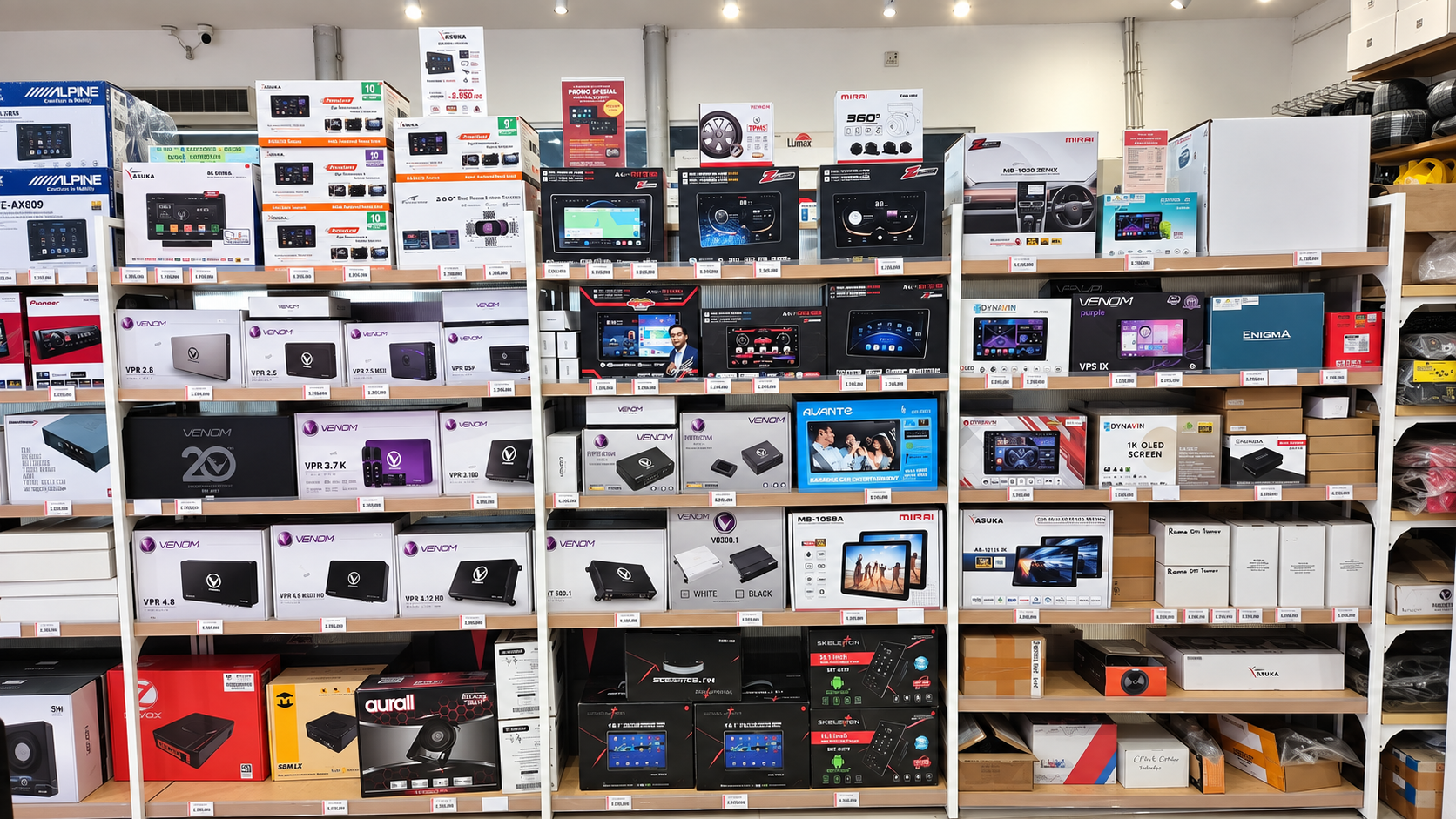 Display fisik berbagai merek Head Unit dengan label harga di Platinum Auto Center